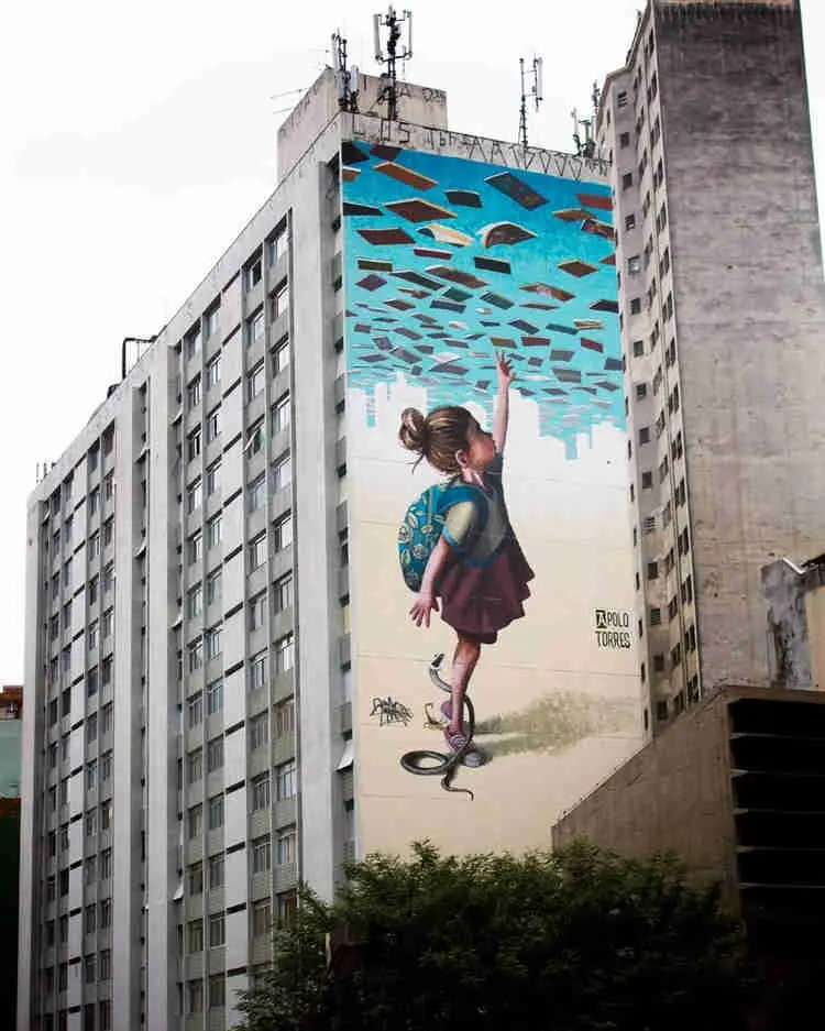 Menina pegando livros no ceu, grafite em empena cega de Apollo Torres